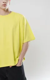 Remera de corte boxy, silueta amplia y recta, con cuello redondo y mangas cortas. Confeccionada en algodón premium, presenta un calce relajado y moderno.