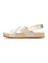 Sandalia plana color beige, con tiras cruzadas en el empeine y tira ajustable con hebilla en el talón. Suela corrida de tono claro con base de goma.