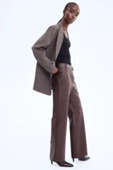 Pantalón de tejido revestido color marrón oscuro, de corte recto y tiro alto, con pretina prolongada y cierre frontal.