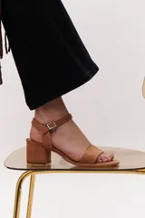 Sandalia de taco cuadrado bajo, confeccionada en gamuza azul, con tira frontal decorada con glitter multicolor y cierre de pulsera con hebilla metálica al tobillo.