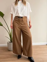 Pantalón de tiro alto y calce fluido, confeccionado en una mezcla de Tencel y lino. Presenta una silueta amplia de corte recto, bolsillos frontales con solapa y trabillas en la cintura.