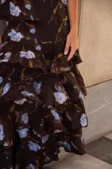 Conjunto de dos piezas compuesto por un top de tirantes finos con volados en el escote y una falda larga de corte evasé con volados en capas. Presenta un estampado floral en tonos azules sobre fondo oscuro.