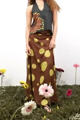 Falda larga de gasa con estampado de lunares grandes en tonos marrón y verde lima. Presenta un diseño de doble tela con caída fluida y cierre lateral oculto.