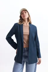 Blazer color beige estilo lino, de corte recto y largo a la cadera.