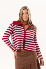Saco tejido de punto a rayas horizontales en color celeste y rojo, con cuello alto, cierre frontal doble deslizador y puños con diseño en contraste. Presenta un pequeño bordado en el pecho.