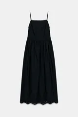 Vestido midi negro de escote recto con tirantes finos ajustables, espalda descubierta y falda amplia con bajo de bordados perforados a tono y detalle de puntilla.