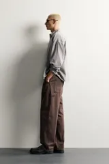 Pantalón jeans de corte relaxed fit, color celeste con efecto lavado, de estilo carpintero con bolsillos laterales y presillas de herramientas.