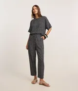 Pantalón carrot de crepé con cintura alta, estampado geométrico en blanco y negro, y lazo en la cintura.