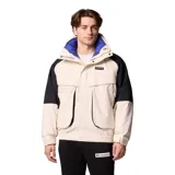 Campera técnica Columbia de la colección Iconos, con diseño impermeable y transpirable Omni-Tech. Presenta un estilo retro con bloques de color en crema y negro, cuello alto con forro interior azul, cierre frontal con solapa protectora y múltiples bolsillos. Incluye sistema de intercambio con cremallera para usar con forro reversible.