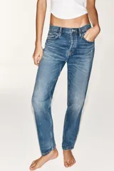 Jeans de tiro medio con corte straight, color azul con efecto lavado y roturas sutiles, cinco bolsillos y cierre frontal con cremallera y botón metálico.