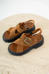 Sandalias de gamuza color suela con diseño de tiras cruzadas en el empeine, ajuste con hebilla metálica lateral y suela track negra de plataforma.