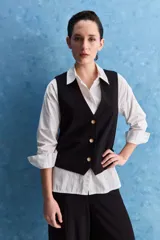 Chaleco negro con escote en V, cierre frontal con botones y bolsillos ribeteados simulados.