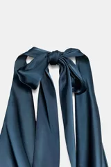 Top de tejido satinado color negro, con cuello halter anudado en la nuca y escote drapeado.