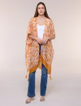 Kimono de gasa ligera con diseño estampado en tonos naranja y blanco, corte amplio y abierto al frente, mangas cortas integradas y detalle de borlas en el ruedo asimétrico.