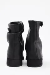 Botin de cuero vacuno color marrón con diseño de caña arrugada, punta redondeada y suela de plataforma negra con taco cuadrado.