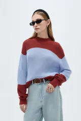 Sweater de punto holgado con cuello alto, diseño multicolor de bloques en tonos bordó, celeste y rojo, de manga larga.