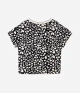 Blusa de crepé con estampa de manchas en blanco y negro, mangas cortas y escote en pico con borde contrastante.