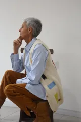 Chaleco tejido a mano en lana merino, con escote en V, cierre frontal de botones de madera y diseño con detalles geométricos de colores.