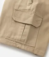 Bermuda cargo negra confeccionada en sarga de algodón, con cintura tradicional, cierre de cremallera y botón, y bolsillos laterales útiles.