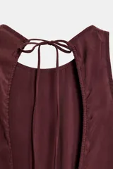Vestido midi fluido de mezcla de viscosa en color bordó, con cuello redondo, manga sisa y detalle de lazada con abertura en la espalda.