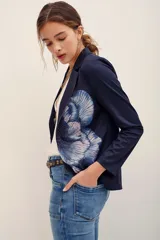 Saco de sastre azul marino con estampado floral en tonos celestes y rosados, con solapas y cierre frontal de un botón.