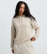 Buzo tipo hoodie de corte oversized en color beige, con mangas largas, puños ajustados y capucha con cordón de ajuste. Confeccionado en tejido modal suave y transpirable.
