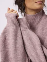 Sweater de punto en color gris, con cuello alto tipo tortuga y diseño de calce holgado con mangas largas.
