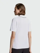 Remera polo de algodón blanca con cuello en V y detalles de líneas finas en contraste. Presenta mangas cortas y el logo de la marca aplicado en el pecho.