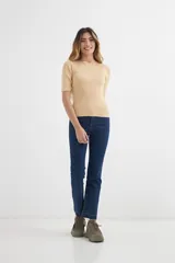 Sweater de punto color beige, ajustado al cuerpo, con cuello bote y mangas cortas.