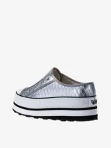 Zapatilla tipo slip-on con diseño de plataforma alta, acabado metalizado plateado con textura de reptil y suela de goma con franjas negras.