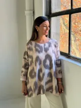 Sweater de punto con estampado abstracto tipo animal print en tonos gris y beige, de corte holgado, cuello redondo y mangas tres cuartos con dobladillo.