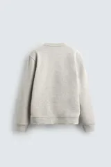Sudadera de cuello redondo y manga larga, confeccionada en tejido de algodón pesado con interior de rizo ligeramente afelpado. Presenta un corte relajado y acabados en rib en puños y ruedo.