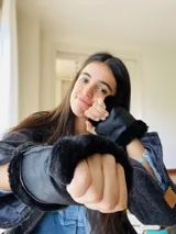 Guantes sin dedos confeccionados en cuero negro con ribetes de corderito al tono en los extremos. Presentan un diseño abrigado y una pequeña etiqueta de marca en el lateral.