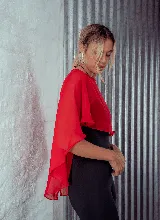 Capa de microtul color verde oscuro con diseño versátil, cierre frontal con botón y corte amplio con caída fluida.