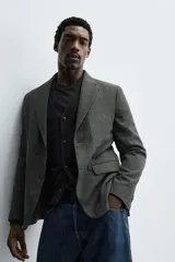 Blazer slim fit de estructura con diseño de pata de gallo, cuello con solapas de muesca, manga larga con botones en puños, bolsillos de solapa en cadera y cierre frontal con botones.