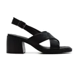 Sandalia de cuero sintético color negro, con tiras cruzadas en el empeine, pulsera con hebilla al tobillo y taco cuadrado bajo.