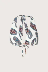 Top de bikini halter con estampado paisley en tonos azules, rojos y marrones sobre fondo blanco. Cuenta con tiras para atar al cuello y en la espalda, y detalle de argolla metálica en el centro con cordones ajustables terminados en terminales metálicas.