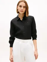 Camisa de lino puro color negro de Tommy Hilfiger, con cuello inglés, manga larga y cierre frontal de botones. Presenta un pequeño logo bordado en el pecho.