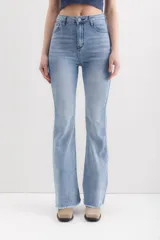 Pantalón de jean celeste de corte acampanado, tiro alto y ruedo desflecado.
