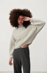 Sweater tejido verde esmeralda de alpaca y lana, con cuello redondo y mangas abullonadas.