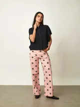 Pantalon tipo jean de corte recto, color rosado con estampa de lunares negros.
