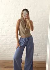 Pantalón palazzo celeste a rayas verticales blancas, de tiro alto y corte holgado.