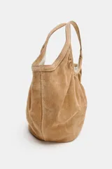 Bolso de hombro formato mini shopper confeccionado en piel de ante, con diseño fruncido, doble asa de mano y cierre mediante clip metálico.