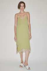 Vestido midi confeccionado en hilatura de viscosa, de color verde con detalles de encaje a contraste en el escote y el bajo. Cuenta con escote recto y tirantes finos ajustables.