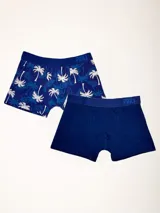 Pack de dos boxers de largo medio, uno liso azul y otro estampado con palmeras blancas sobre fondo azul. Elástico visible en la cintura con logo de la marca.