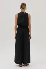Pantalón de pierna ancha confeccionado en lino, con cintura elástica, tiras regulables y abertura en el bajo.