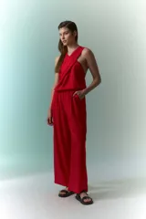 Mono rojo con cuello halter, corte holgado y pierna ancha.