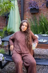 Sweater tejido con diseño de rombos geométricos en relieve, de cuello redondo y manga larga con silueta amplia.