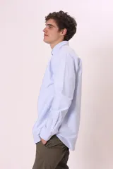 Camisa de manga larga para hombre, color blanco con finas rayas verticales azules, cuello button-down y corte regular.