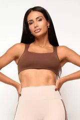 Top deportivo de entrenamiento con escote redondeado y espalda tipo nadador, confeccionado en poliamida tecnológica de alto rendimiento. Cuenta con forro interno y abertura para colocar almohadillas.